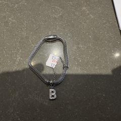 Zilveren armband met letter B, amint azt az iLostnak jelentették.