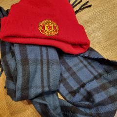 red Manchester United top hat, and a blue scarf, segons ha informat MEININGER Hotel Amsterdam City West mitjançant iLost