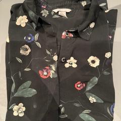Blúz zwart met bloemen, amint azt Van der Valk Hotel Deventer az iLost segítségével jelentette.